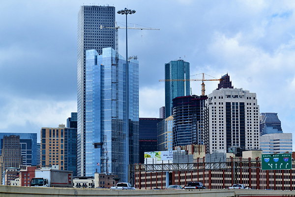 Houston, USA, skyline with several tall office towers and a construction crane against a cloudy sky